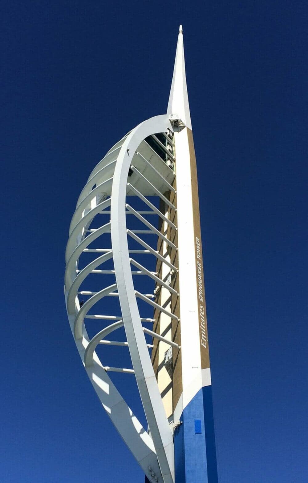 Spinnaker Tower in Portsmouth against a clear blue sky, showcasing its sail-like design and white structural elements. - Home Instead