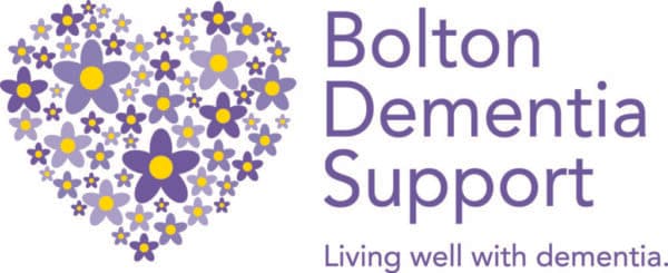 Heart made of purple and yellow flowers beside text: Bolton Dementia Support. Living well with dementia. - Home Instead