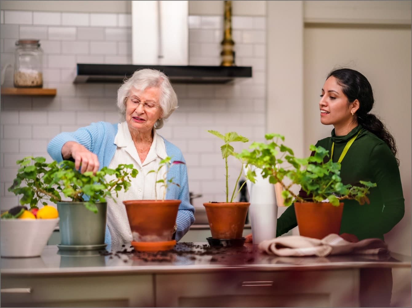 A woman in a face mask assists an elderly man using a walker on a path outdoors. - Home Instead