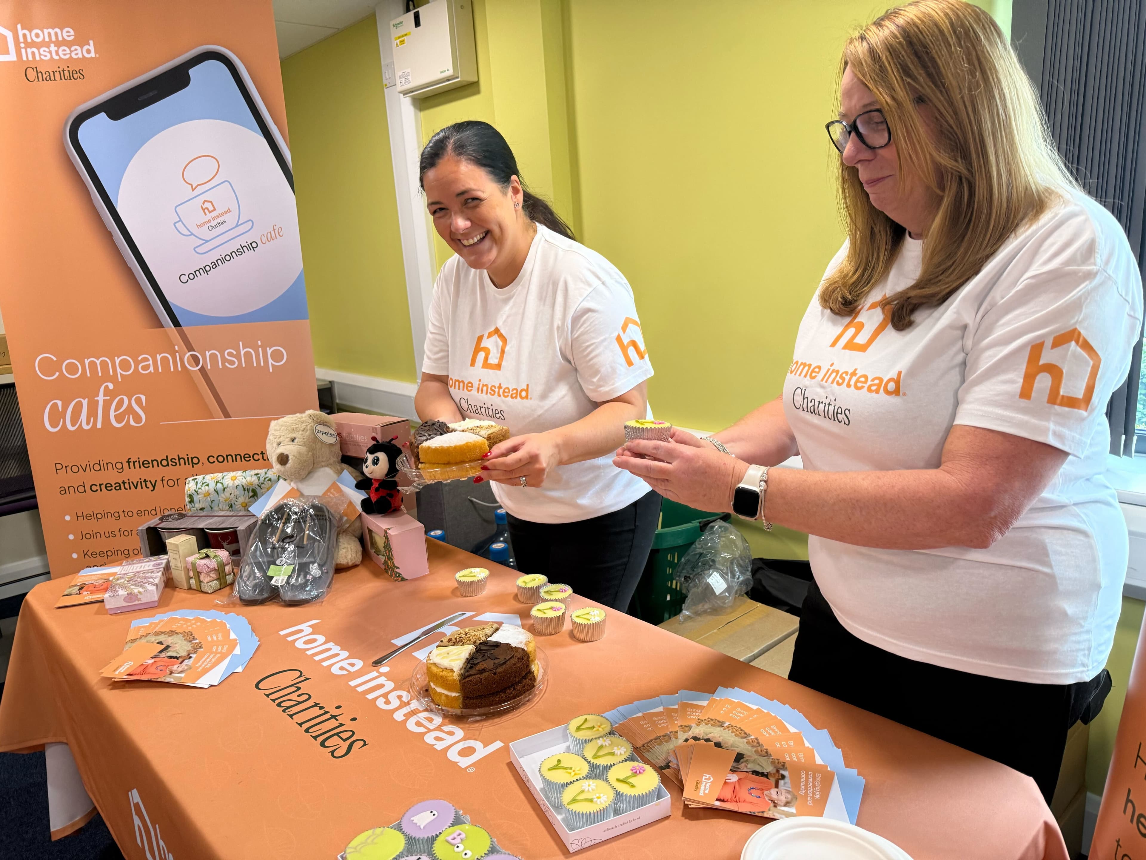 Two women at a Home Instead charity bake stall