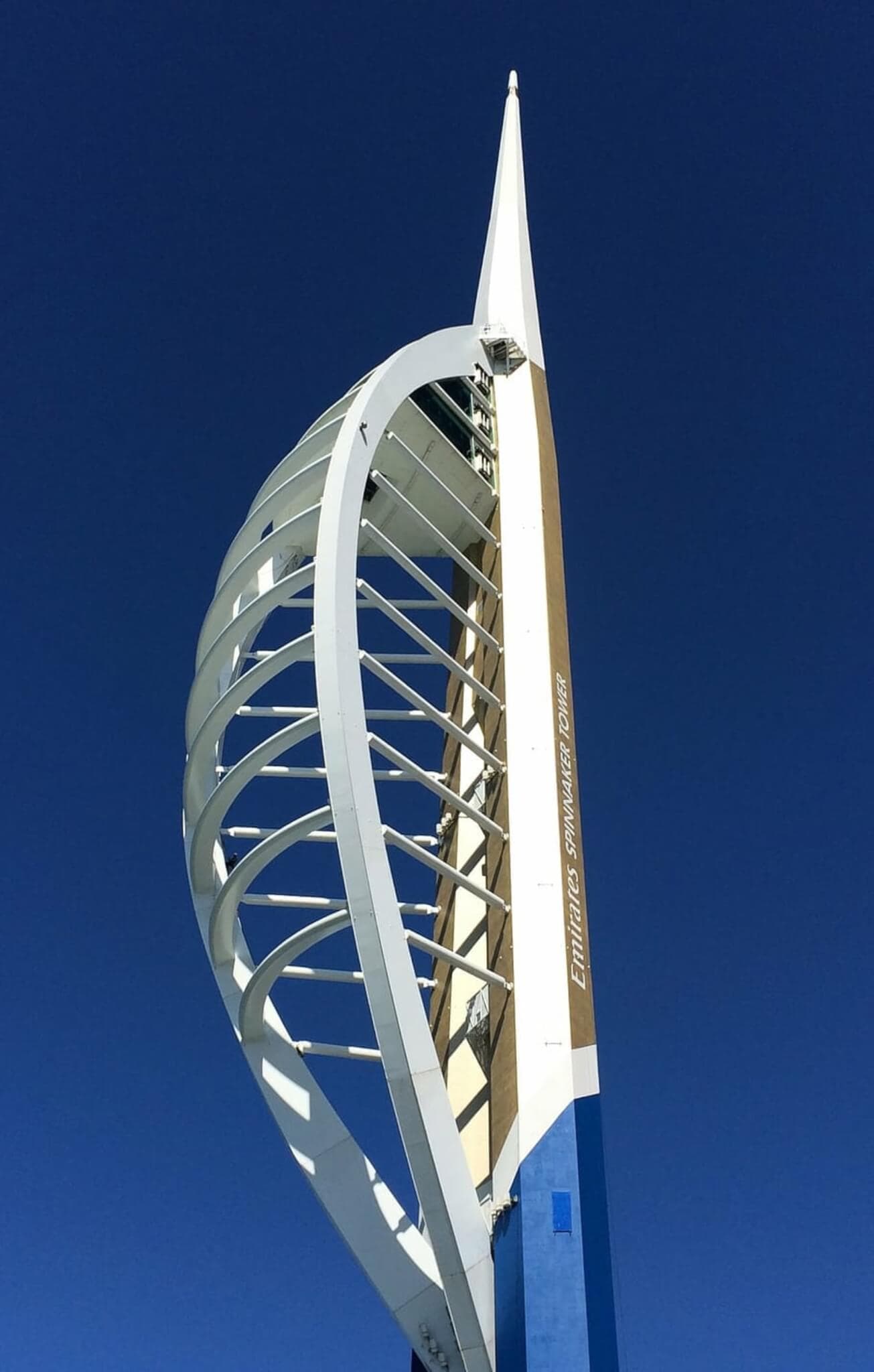 Spinnaker Tower in Portsmouth against a clear blue sky, showcasing its sail-like design and white structural elements. - Home Instead
