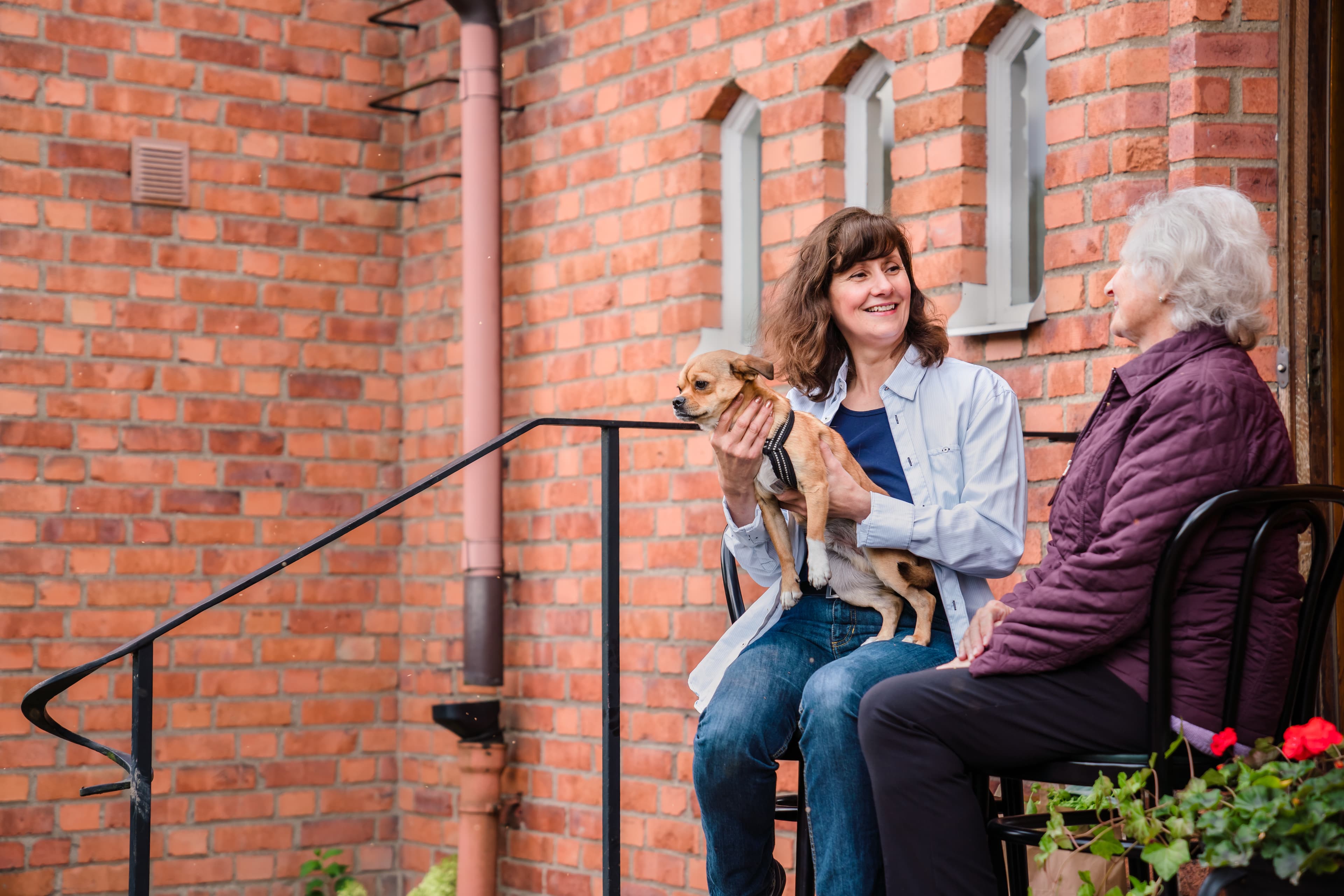 Client with Care Professional holding a dog - Home Instead