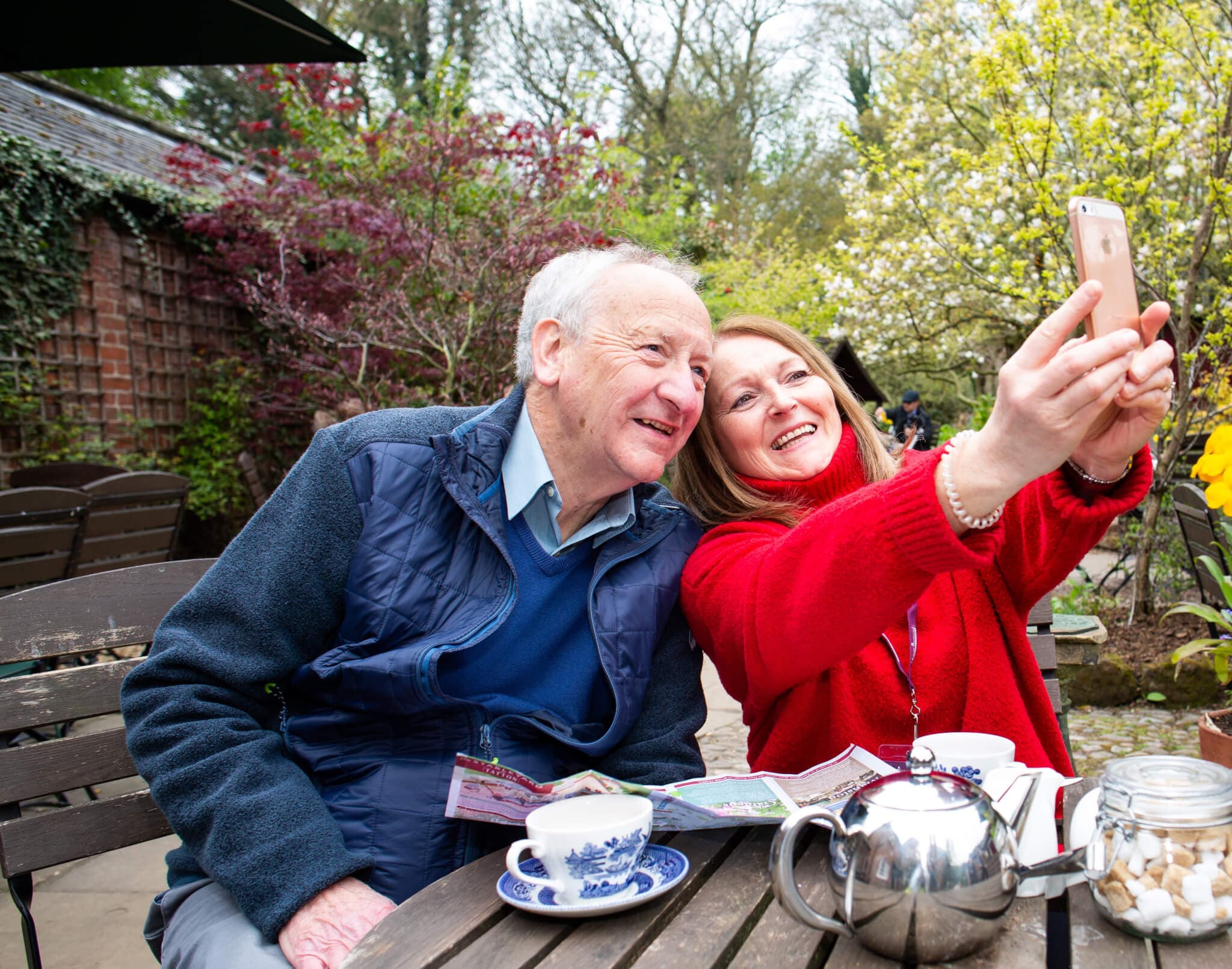 Home Instead carer with her client taking a selfie in a garden centre