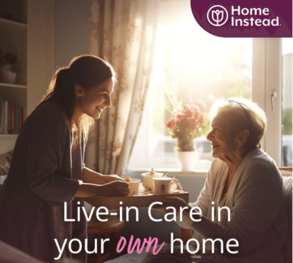 A caregiver serves tea to an elderly woman by a window, with the text "Live-in Care in your own home" and the "Home Instead" logo. - Home Instead