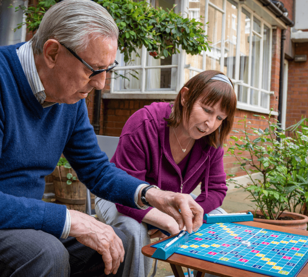 Home Instead Southampton Care Professional and client playing Scrabble together outdoors