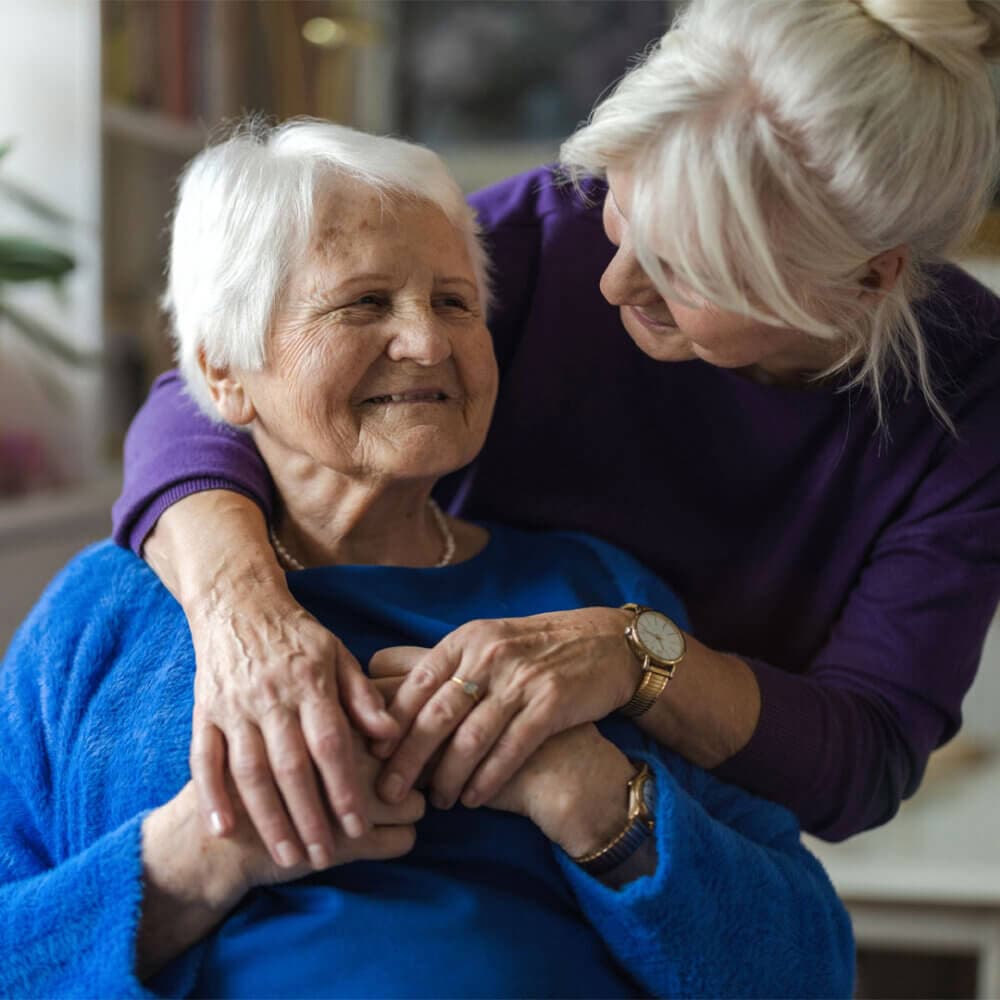 Daughter hugging her elderly Mum