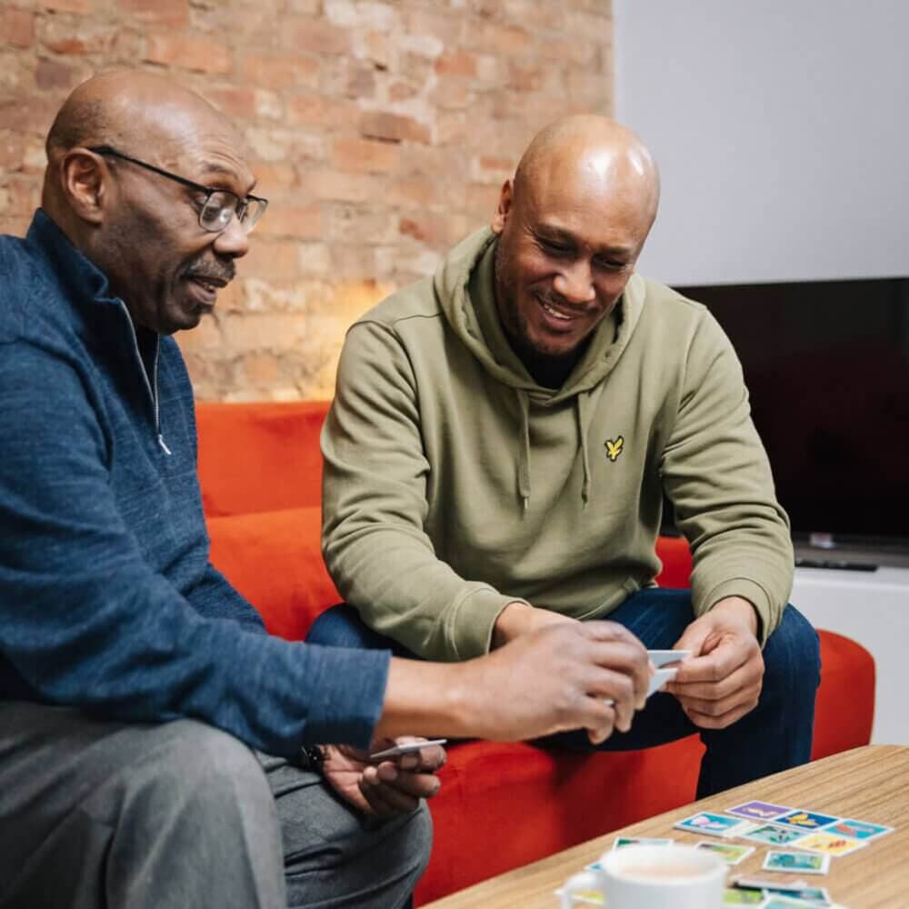 live in care professional playing cards with his client