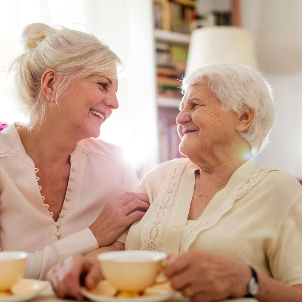 elderly mum and daughter sitting and chatting together