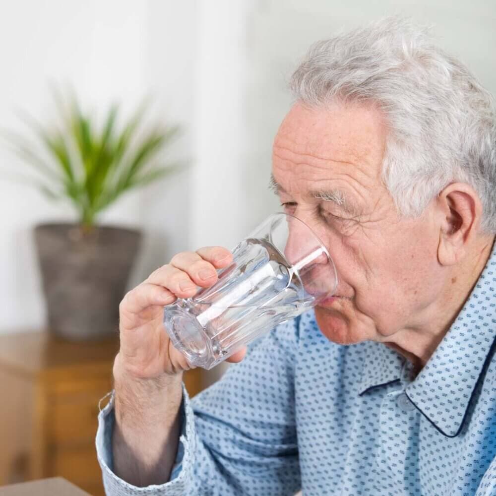older man drinking a glass of water
