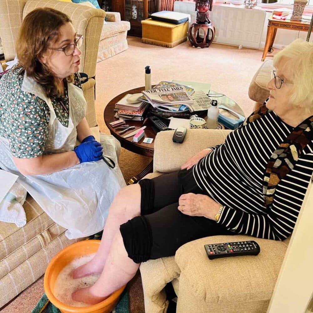 Liz Thew soaking her feet during her home instead home nail care session