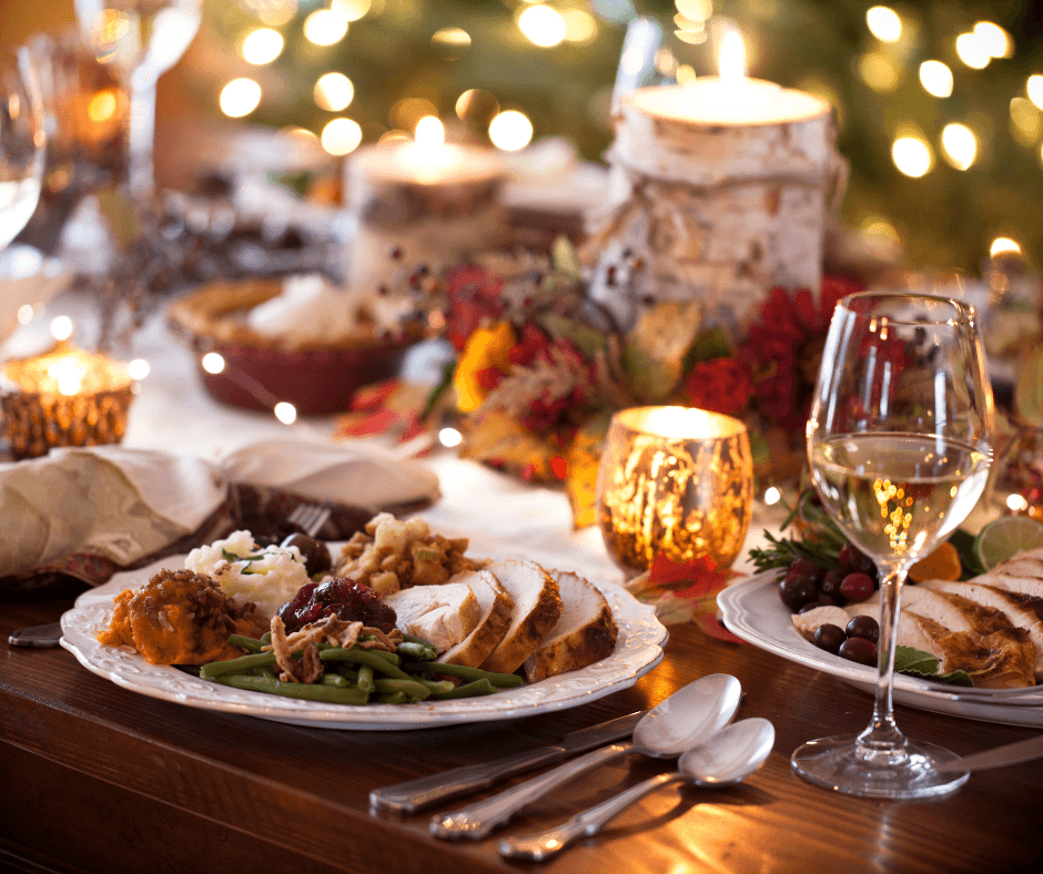 Festive Christmas dinner table with candles, plated turkey, green beans, and wine glasses. - Home Instead