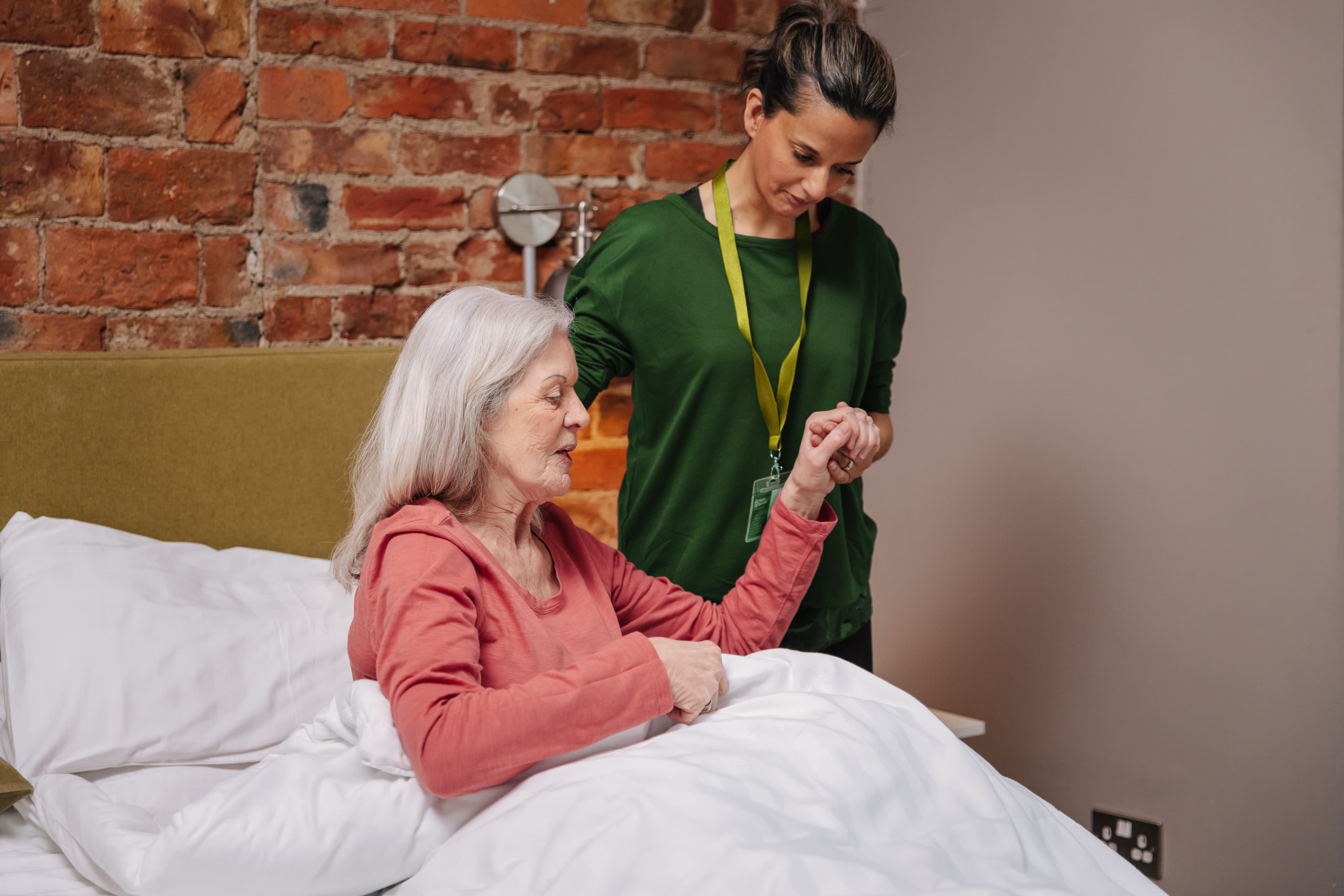 Care Professional helps client out of bed - Home Instead