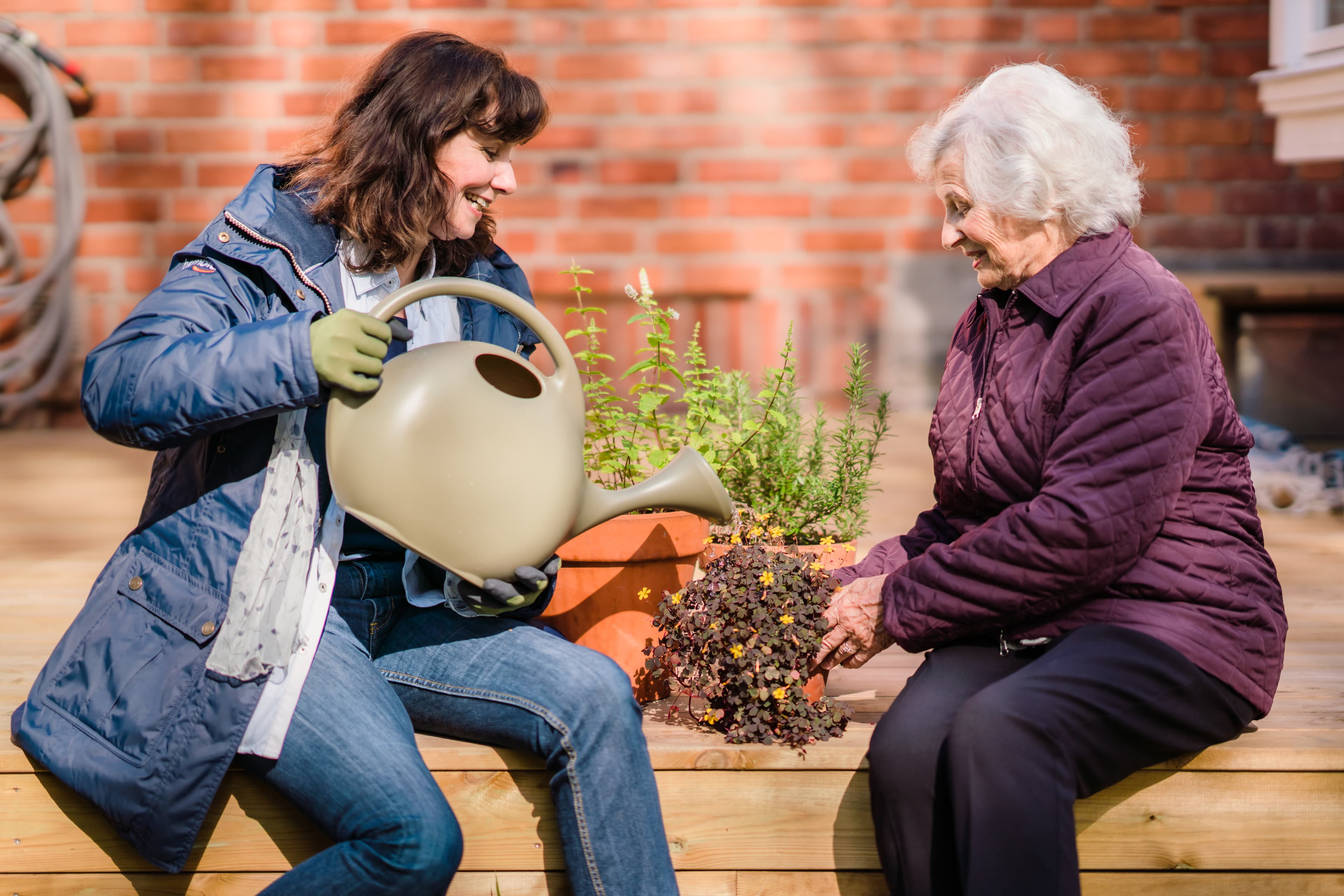 Care Professional watering plant with client - Home Instead