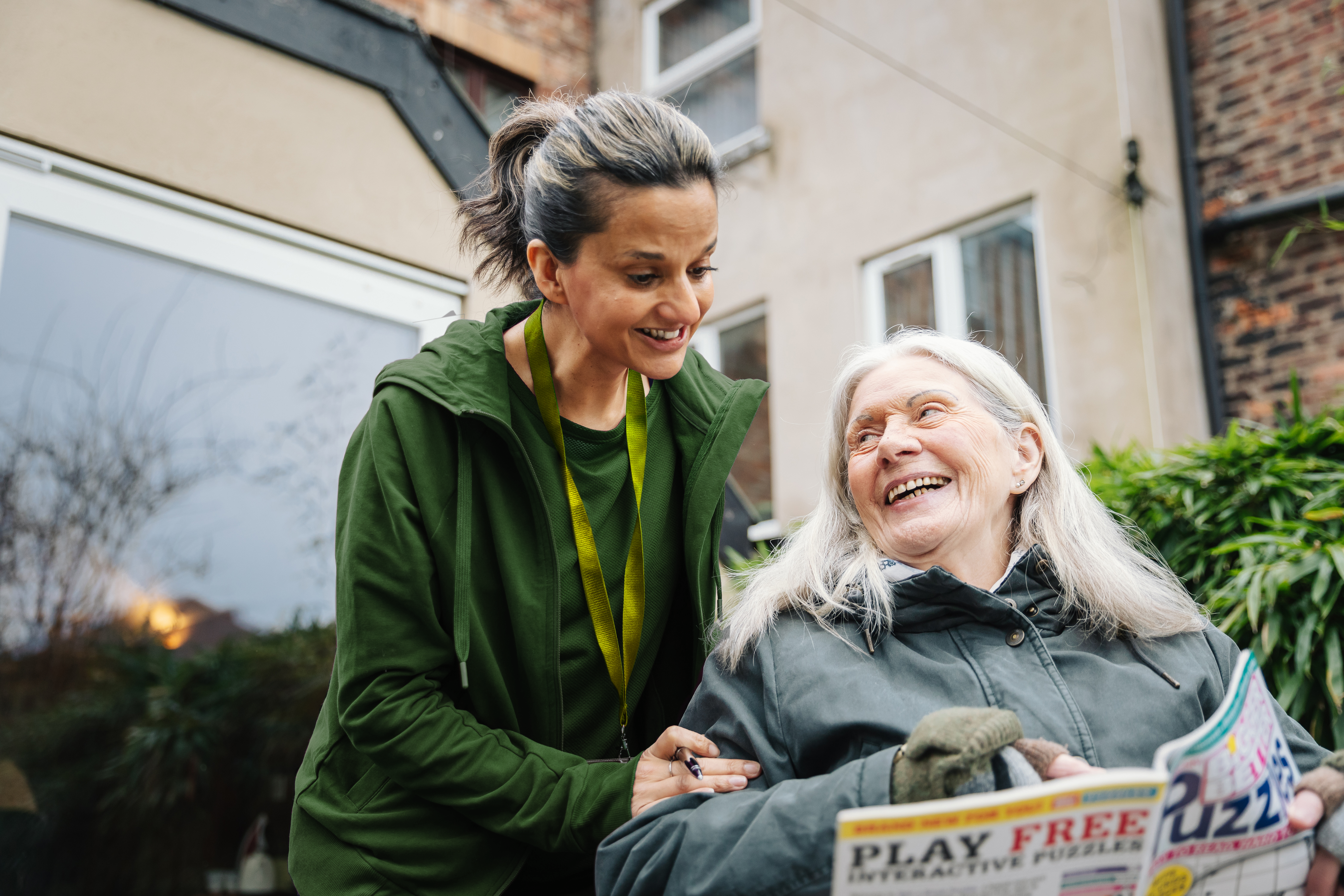 female care pro and client outside, client solving a puzzle.